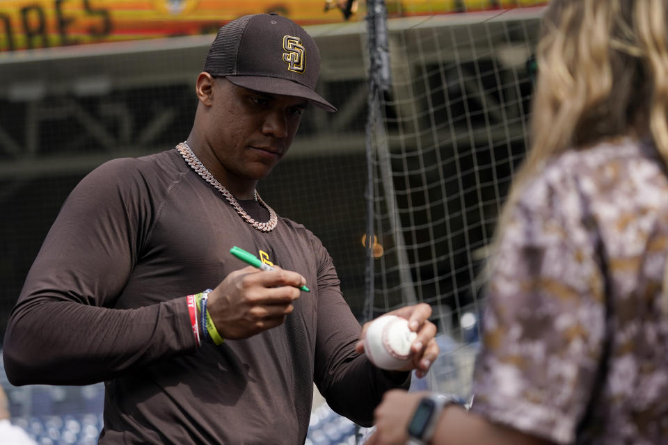 San Diego Padres right fielder Juan Soto signs autographs during batting practice before team's baseball game against the Colorado Rockies on Wednesday, Aug. 3, 2022, in San Diego. (AP Photo/Gregory Bull)