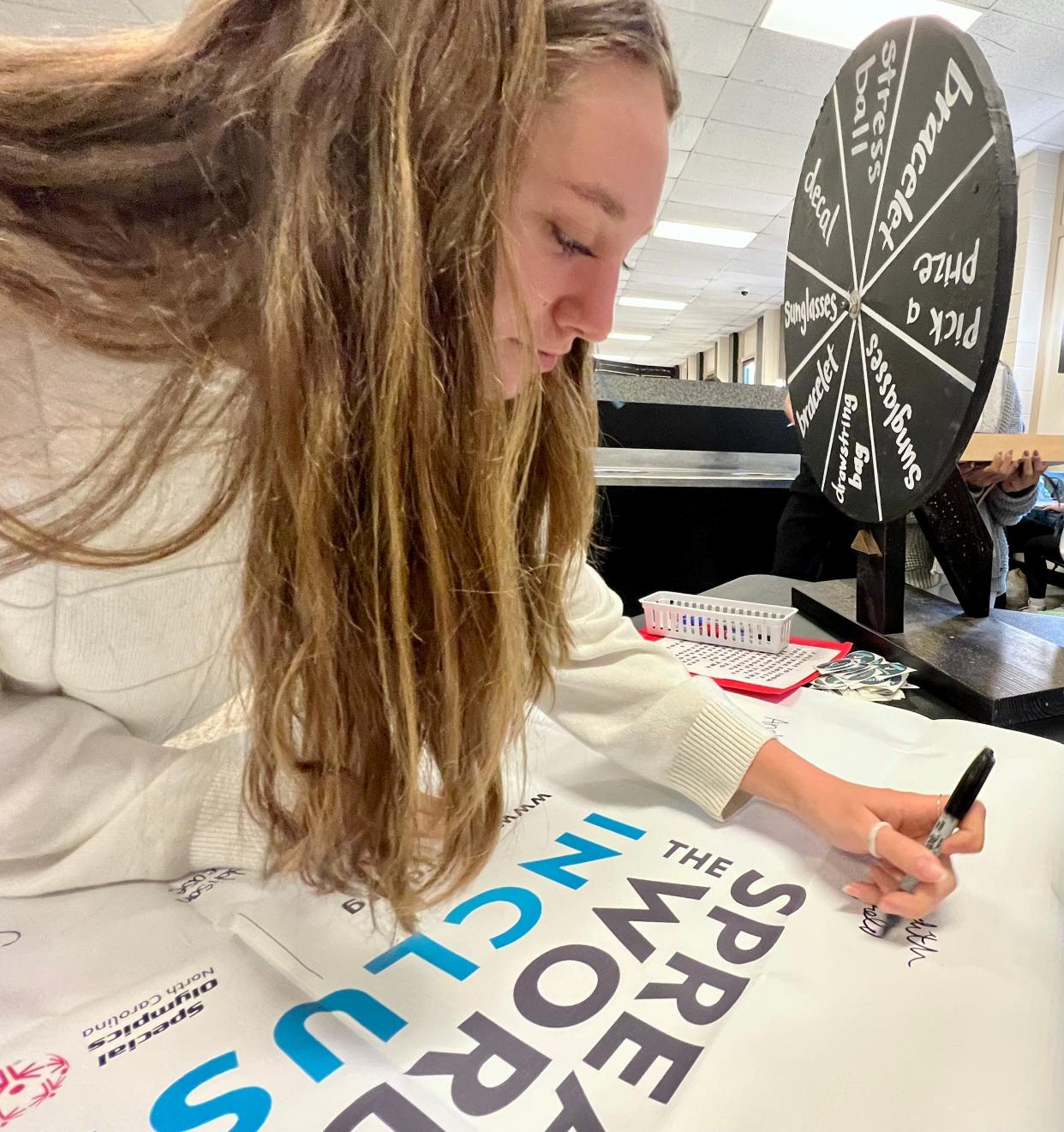 Meredith Benfield signs a pledge to be more inclusive toward students with disabilities at Shelby High School