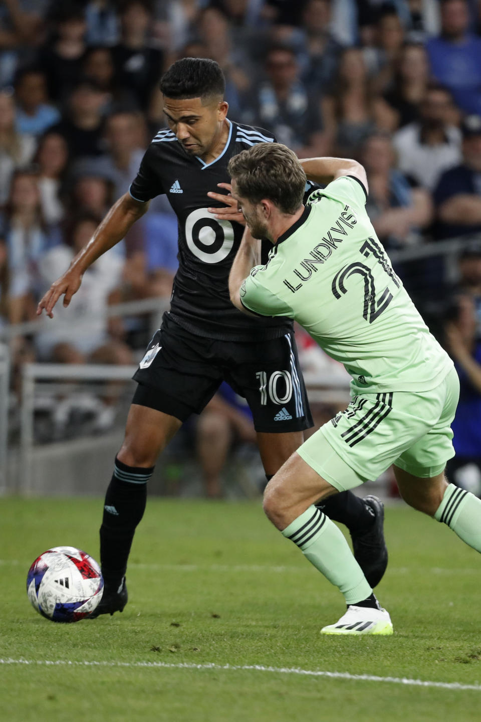 Minnesota United midfielder Emanuel Reynoso (10) works the ball around Austin FC defender Adam Lundqvist (21) in the second half of an MLS soccer game Saturday, July 8, 2023, in St. Paul, Minn. (AP Photo/Bruce Kluckhohn)