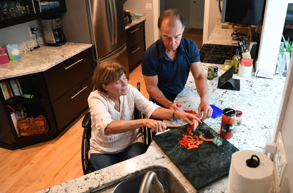 Nancy Poon, who has ALS, is shown in her Rhode Island kitchen with husband Alan Poon.