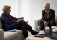 German Chancellor Angela Merkel speaks with former U.S. President Bill Clinton in her office at the Chancellery in Berlin, October 8, 2013. REUTERS/Odd Andersen/Pool