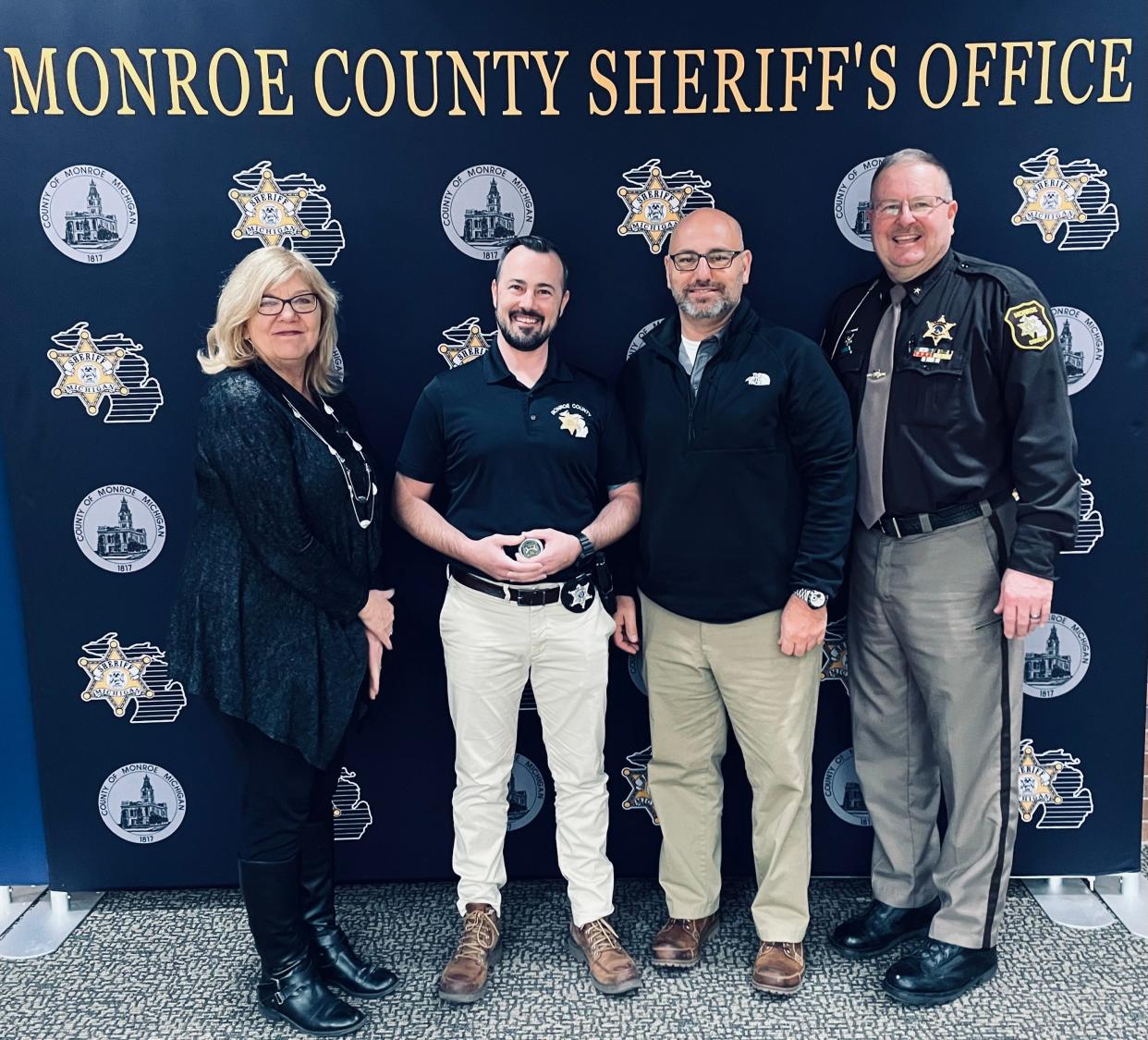 Detective Patrick Davison of the Monroe County Sheriff's Office (second from left) holds a challenge coin presented to him by Gov. Gretchen Whitmer for his work to investigate the death of a local dog who was poisoned. Also pictured (from left) are Michigan Department of Agriculture and Rural Development Acting Director Kathy Angerer, Detective Sgt. Mike Preadmore and Sheriff Troy Goodnough. MDARD started the investigation.