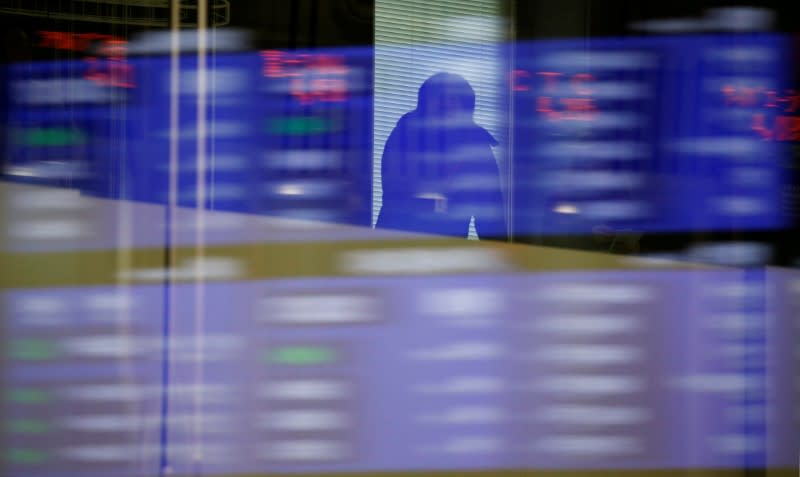 FILE PHOTO: A visitor is seen as market prices are reflected in a glass window at the Tokyo Stock Exchange (TSE) in Tokyo, Japan, February 6, 2018. REUTERS/Toru Hanai/File Photo