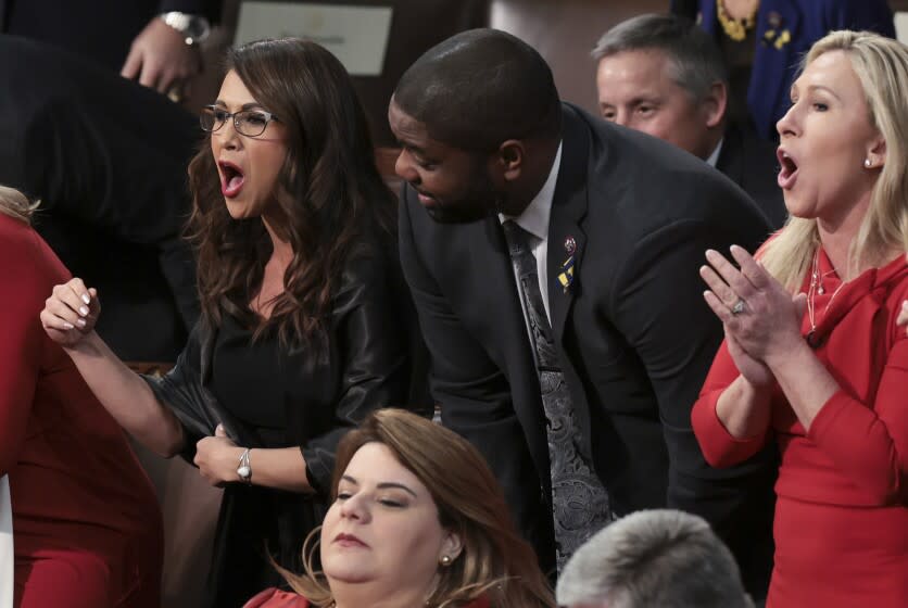 Rep. Lauren Boebert, R-Colo., left, Rep. Byron Donalds, R-Fla., and Rep. Marjorie Taylor Greene, R-Ga., stand with fellow lawmakers as they listen to President Joe Biden deliver his State of the Union address to a joint session of Congress at the Capitol, Tuesday, March 1, 2022, in Washington. (Win McNamee, Pool via AP)