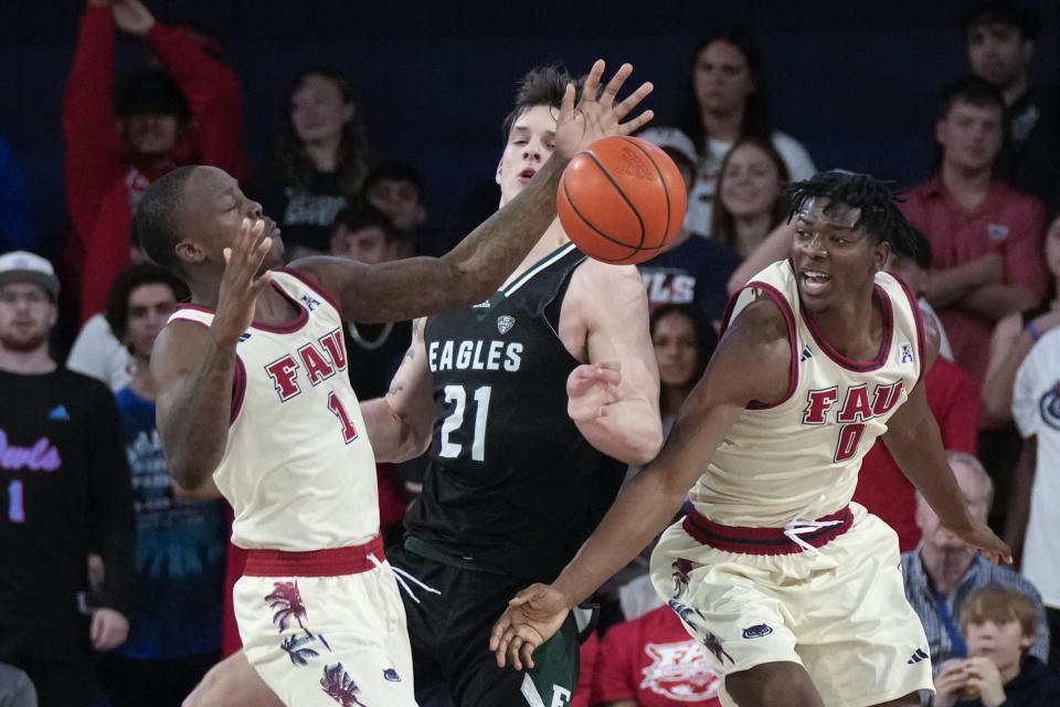 Florida Atlantic guard Johnell Davis (1) reaches for the ball next to forward Brenen Lorient (0) and Eastern Michigan's Cyril Martynov (21) during the first half of an NCAA college basketball game Tuesday, Nov. 14, 2023, in Boca Raton, Fla. (AP Photo/Rebecca Blackwell)