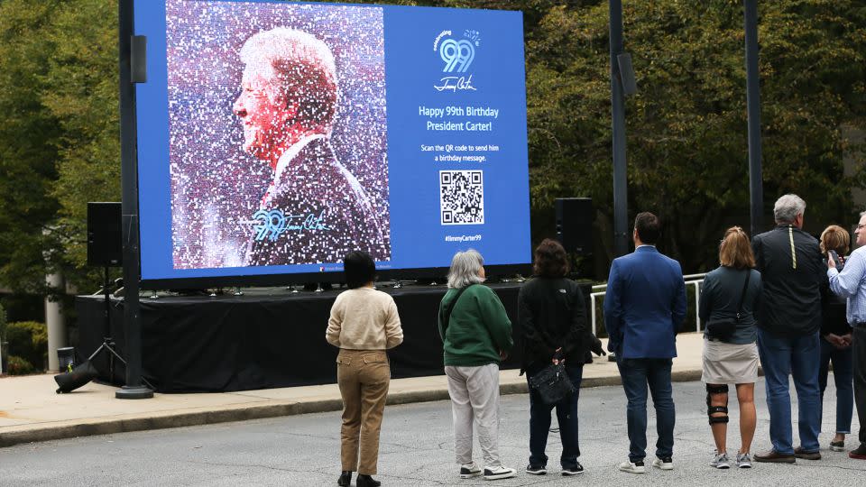 Jimmy Carter's grandson Jason Carter, center, looks Thursday at a digital mosaic of his grandfather at The Carter Center. - Austin Steele/CNN