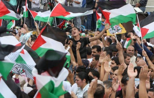 Thousands of cheering Palestinians welcome their president Mahmud Abbas outside his Ramallah headquarters on September 25