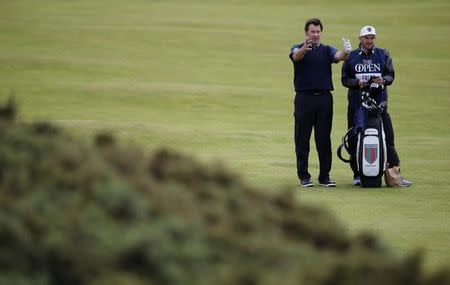 Nick Faldo of England (L) talks with his caddie as he stands on the fourth fairway during the second round of the British Open golf championship on the Old Course in St. Andrews, Scotland, July 17, 2015. REUTERS/Paul Childs