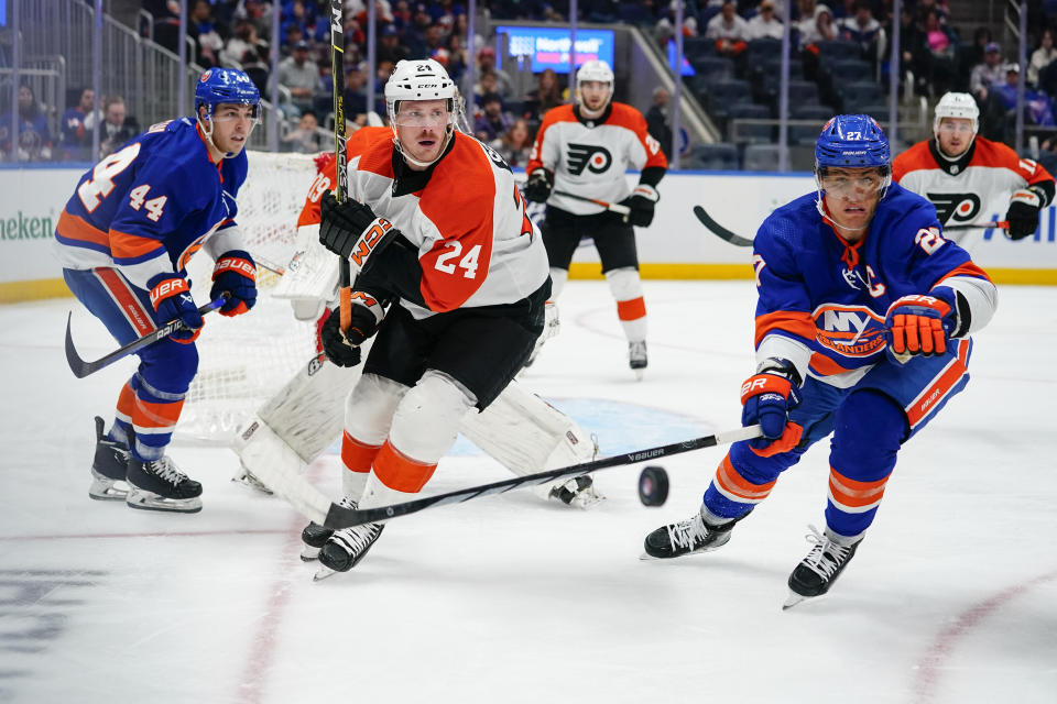 Philadelphia Flyers' Nick Seeler (24) vies for control of the puck against New York Islanders' Anders Lee (27) and Jean-Gabriel Pageau (44) during the second period of an NHL hockey game Wednesday, Nov. 22, 2023, in Elmont, N.Y. (AP Photo/Frank Franklin II)