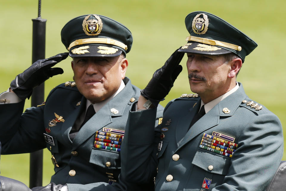 FILE - In this Dec. 17, 2018 file photo, Army Commander Gen. Nicacio Martinez Espinel, right, salutes during a swearing-in ceremony for the new military and police commanders, in Bogota, Colombia. New evidence has emerged linking Martinez Espinel to the alleged cover up of civilian killings more than a decade ago. The documents, provided to The Associated Press by a person familiar with an ongoing investigation into the extrajudicial killings, come as Martinez Espinel faces mounting pressure to resign over orders he gave troops this year, 2019, to step up attacks in what some fear could pave the way for a return of serious human rights violations. (AP Photo/Fernando Vergara, File)