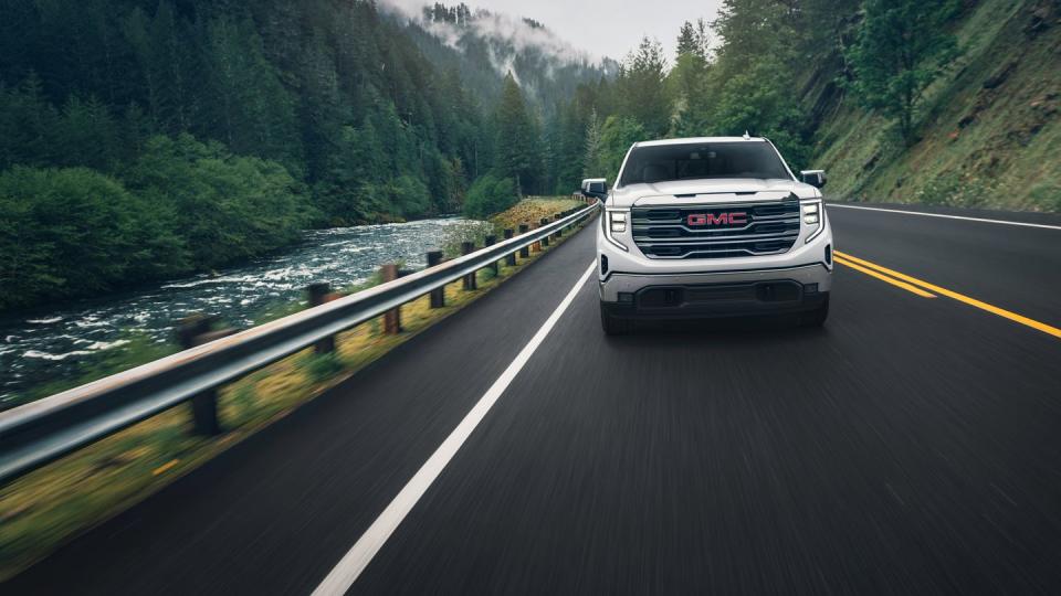 2024 gmc sierra 1500 slt crew cab short box 4wd in white frost tricoat direct front image in motion, driving on bridge next to river