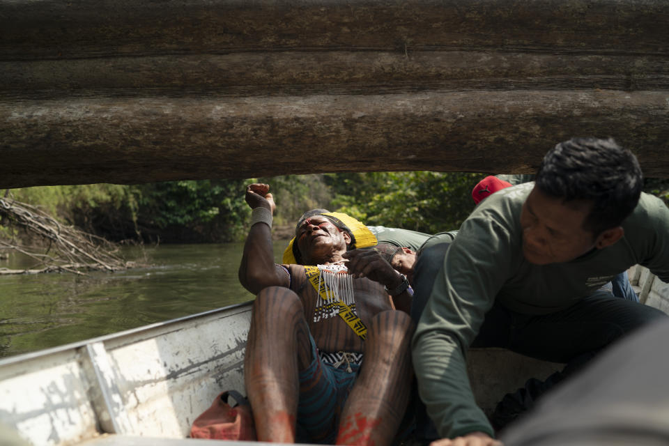 Krimej village indigenous Chief Kadjyre Kayapo, of the Kayapo indigenous community, lays back to pass under a fallen tree on the Pitchacha River as he boats to a bridge constructed by loggers as he surveys Menkragnotire indigenous land in Altamira, Brazil, Saturday, Aug. 31, 2019. Kayapo says that he does not want loggers and prospectors on his land. (AP Photo/Leo Correa)