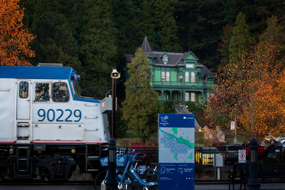 An Amtrak train departs Eugene Station downhill of the Shelton McMurphy Johnson House Museum.