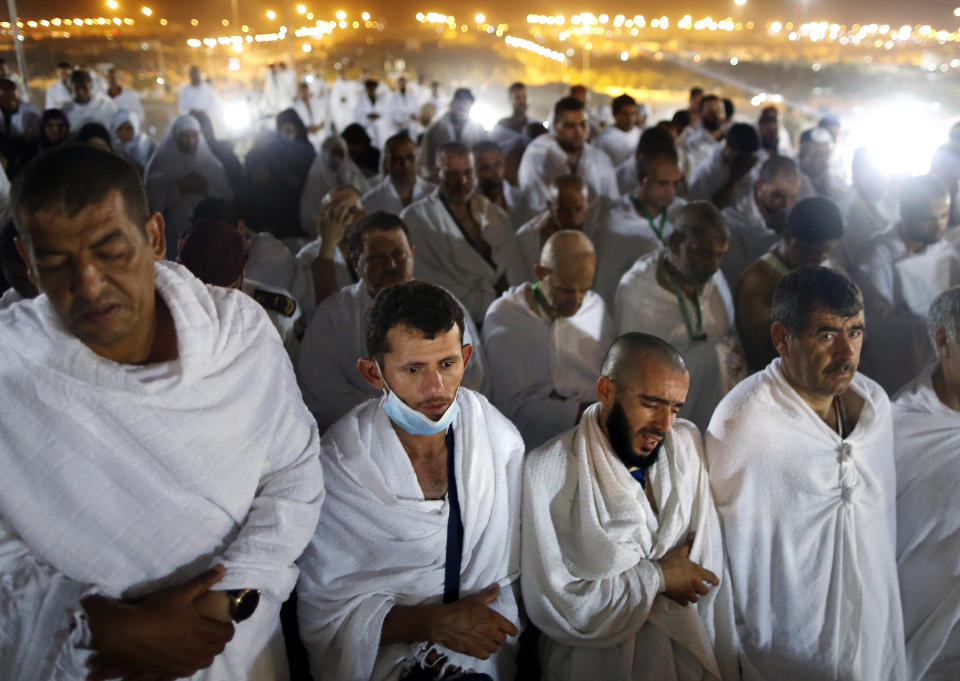 Muslim pilgrims offer dawn prayers on a rocky hill known as Mountain of Mercy, on the Plain of Arafat, during the annual hajj pilgrimage, ahead of sunrise near the holy city of Mecca, Saudi Arabia, Saturday, Aug. 10, 2019. More than 2 million pilgrims were gathered to perform initial rites of the hajj, an Islamic pilgrimage that takes the faithful along a path traversed by the Prophet Muhammad some 1,400 years ago. (AP Photo/Amr Nabil)