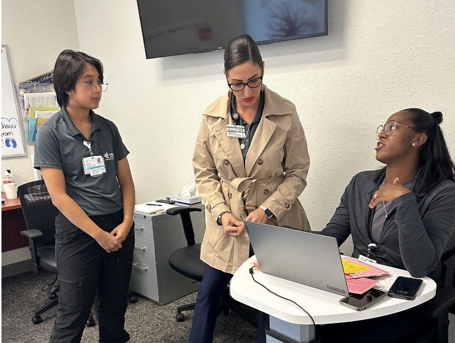 Lavinia Sanchez-Jimenez CMC Medical Assistant, Project Manager Lindsay Lopez and Torrie Piasecki, Behavioral Health Clinical Supervisor/LCSW plan out their daily route in the Mobile Community Response Team office in Stockton on November 17, 2023.