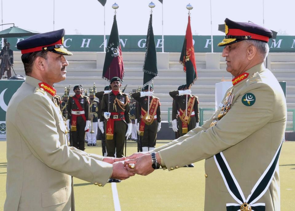 In this photo released by Army's public relations wing 'Inter Services Public Relations', Pakistan's outgoing Army Chief Gen. Qamar Javed Bajwa, right, hands over a ceremonial baton to his successor Gen. Asim Munir during the Change of Command ceremony, in Rawalpindi, Pakistan, Tuesday, Nov. 29, 2022. Pakistan's new army chief Munir, took command of the country's armed forces amid a deepening political rift between the government and the popular opposition leader, as well as a renewed threat from a key militant group that has been behind scores of deadly attacks over 15 years. (Inter Services Public Relations via AP)