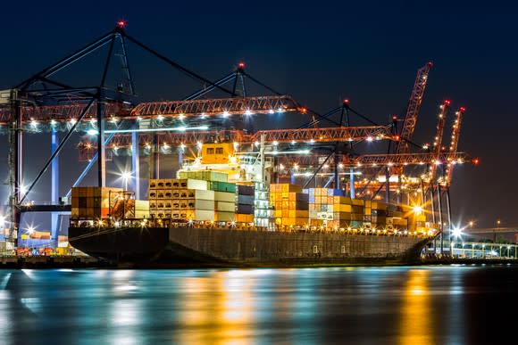A container ship in a port at night.