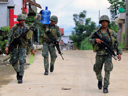 Soldiers walk along the main street in Mapandi village as government troops continue their assault on insurgents from the Maute group, who have taken over large parts of Marawi City, Philippines June 2, 2017. REUTERS/Romeo Ranoco