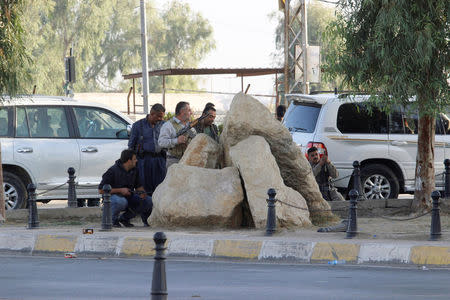 Peshmerga forces stand behind rocks at a site of an attack by Islamic State militants in Kirkuk, Iraq, October 21, 2016. REUTERS/Ako Rasheed