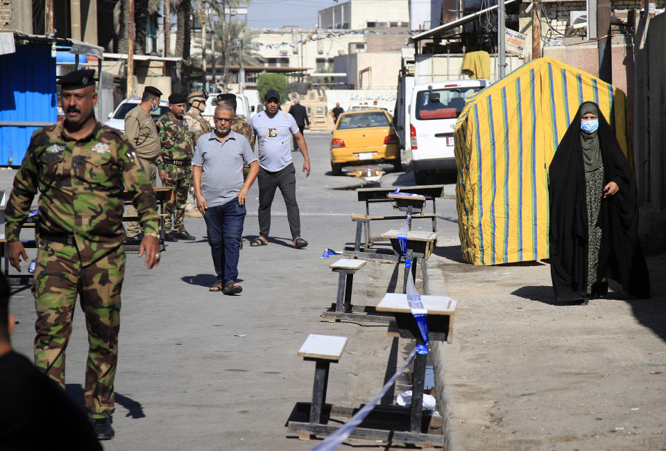 Security forces stand guard outside a polling center duringin the country's parliamentary elections in Baghdad, Iraq, Sunday, Oct. 10, 2021. Iraq closed its airspace and land border crossings on Sunday as voters headed to the polls to elect a parliament that many hope will deliver much needed reforms after decades of conflict and mismanagement. (AP Photo/Hadi Mizban)