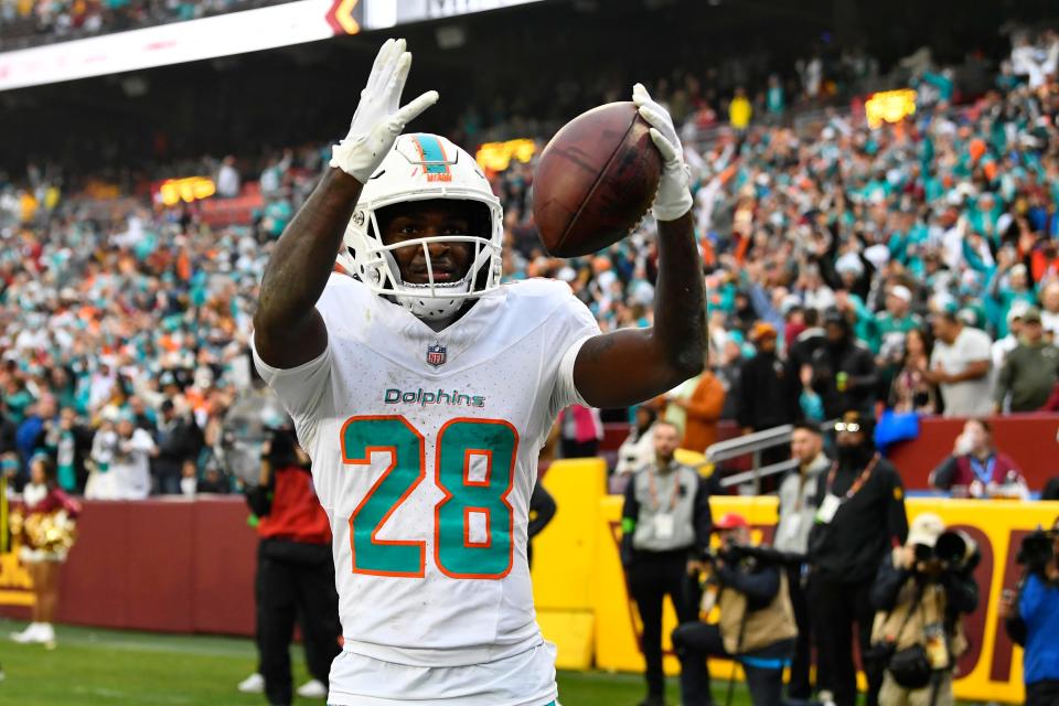 Dec 3, 2023; Landover, Maryland, USA; Miami Dolphins running back De'Von Achane (28) celebrates after scoring a touchdown against the Washington Commanders during the second half at FedExField. Mandatory Credit: Brad Mills-USA TODAY Sports