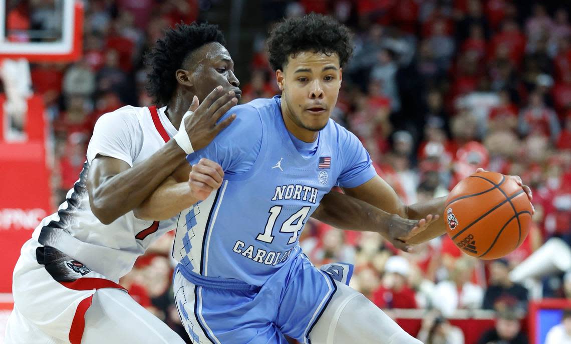 N.C. State’s Jarkel Joiner (1) fouls North Carolina’s Puff Johnson (14) during the first half of N.C. State’s game against UNC at PNC Arena in Raleigh, N.C., Sunday, Feb. 19, 2023.