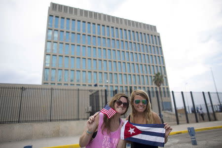 Emily O'Connell (L), 24, and Jordan Gaddis, U.S. citizens on an educational exchange program, pose for photos in front of the U.S embassy in Havana August 11, 2015. REUTERS/Alexandre Meneghini