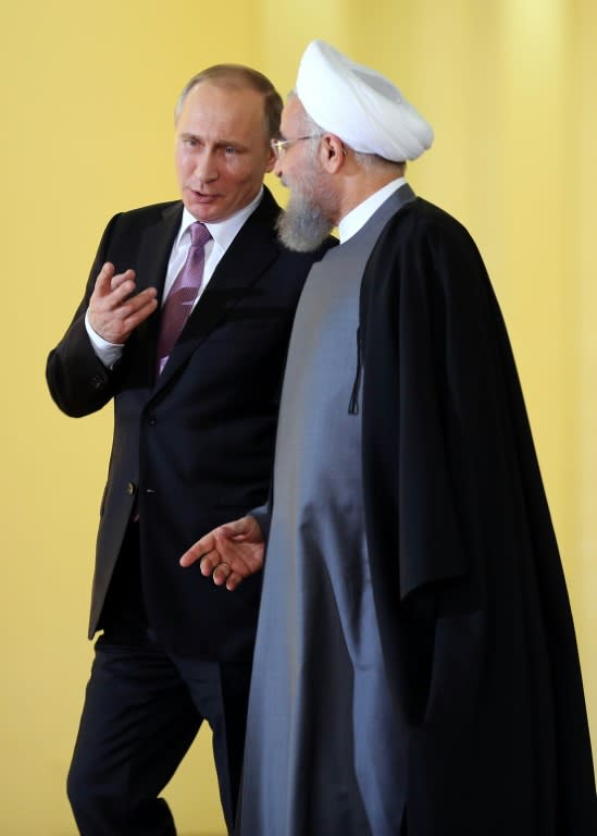 Iranian President Hassan Rouhani (R) talks with his Russian counterpart Vladimir Putin during the Gas Exporting Countries Forum summit in Tehran, on November 23, 2015