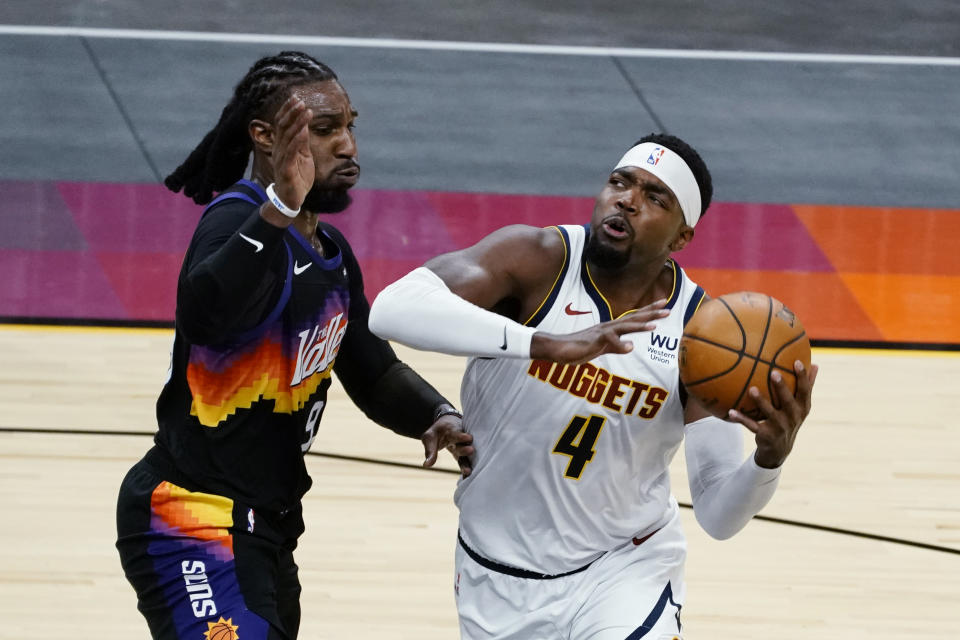 Denver Nuggets forward Paul Millsap (4) drives on Phoenix Suns forward Jae Crowder during the first half of an NBA basketball game Saturday, Jan. 23, 2021, in Phoenix. (AP Photo/Rick Scuteri)