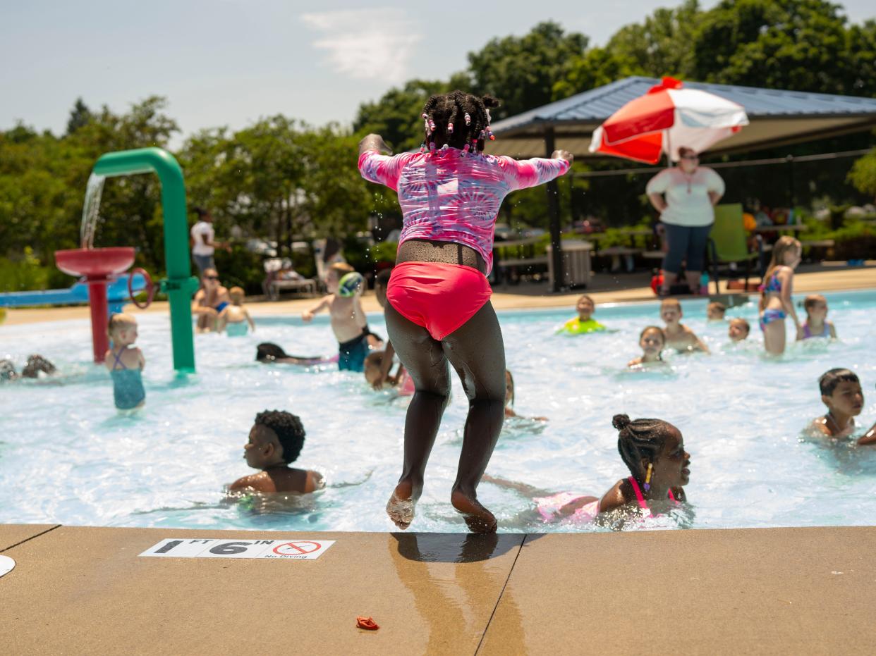 Ziayla McClung, 6, jumps in the splash pad to break the heat on Tuesday, June 14, 2022 at Kennedy Park in South Bend.