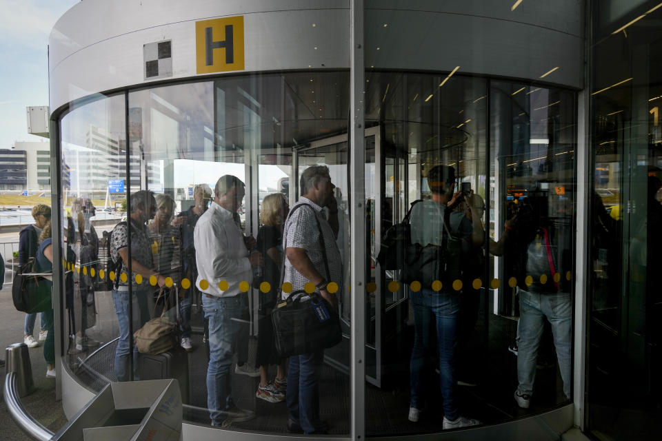 FILE - Travelers wait in long lines to check in and board flights at Amsterdam's Schiphol Airport, Netherlands, Tuesday, June 21, 2022. (AP Photo/Peter Dejong, File)