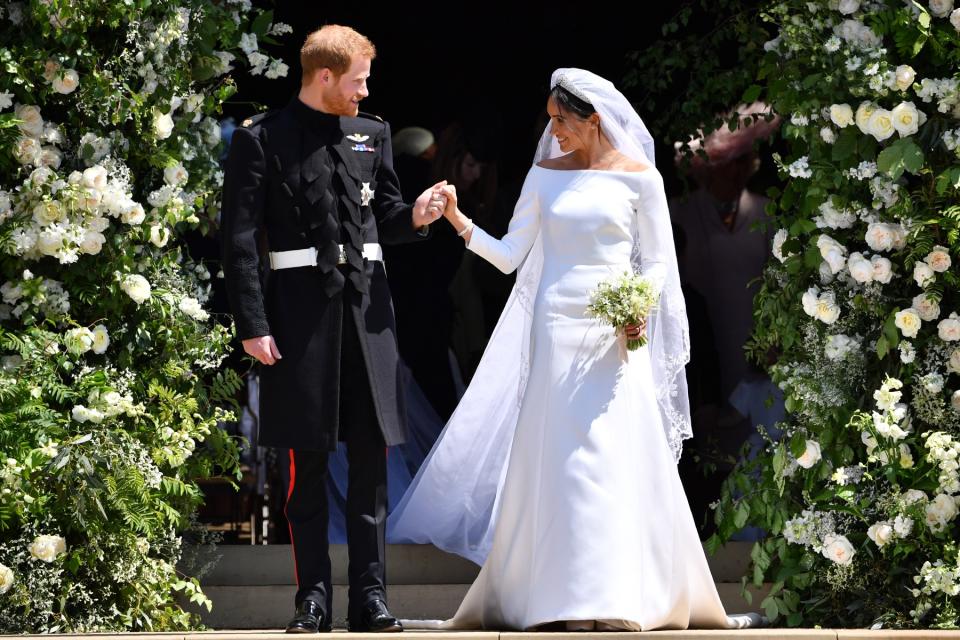 Britain's Prince Harry, Duke of Sussex and his wife Meghan, Duchess of Sussex leave from the West Door of St George's Chapel, Windsor Castle, in Windsor on May 19, 2018