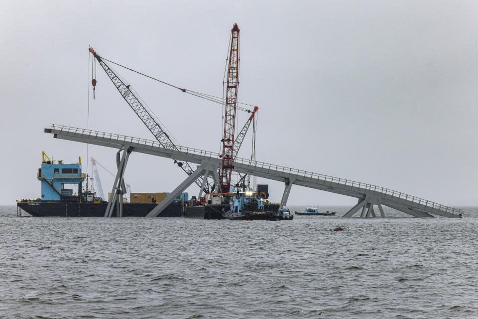 Cranes continue salvage work as wreckage of the Francis Scott Key Bridge rests on the container ship Dali, Wednesday, April 3, 2024, in Baltimore. (AP Photo/Julia Nikhinson)