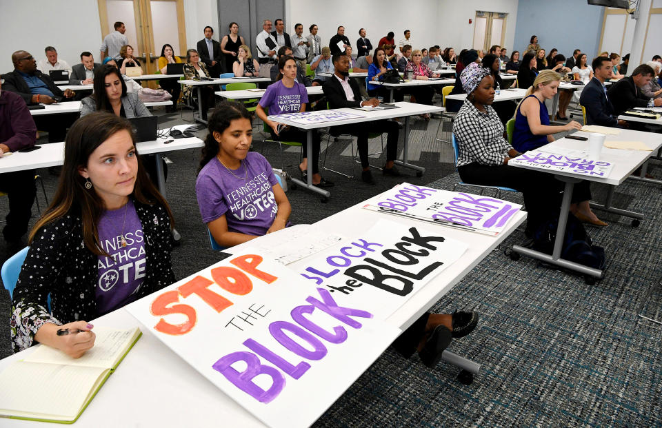 People from the Tennessee Justice Center hold signs at a public hearing on Oct. 1, 2019, in Nashville, Tenn., on Tennessee's request for block grant funding for Medicaid. (Larry McCormack / The Tennessean via USA Today Network file)