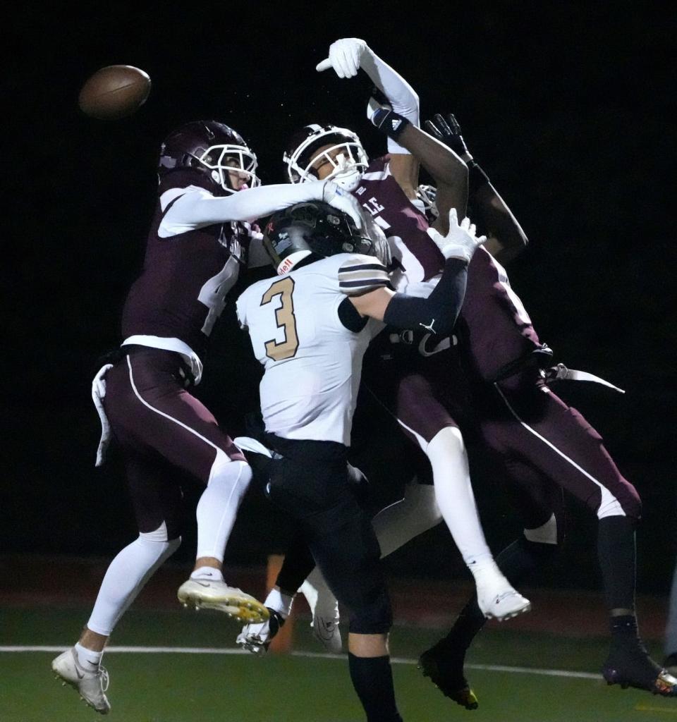La Salle defenders Grover Moran, Herlin Perry and Timoy Stitchell leap over North Kingstown receiver Gian Iacuele going for a pass attempt in the first half. It was incomplete and there was a flag on the play against the Rams.