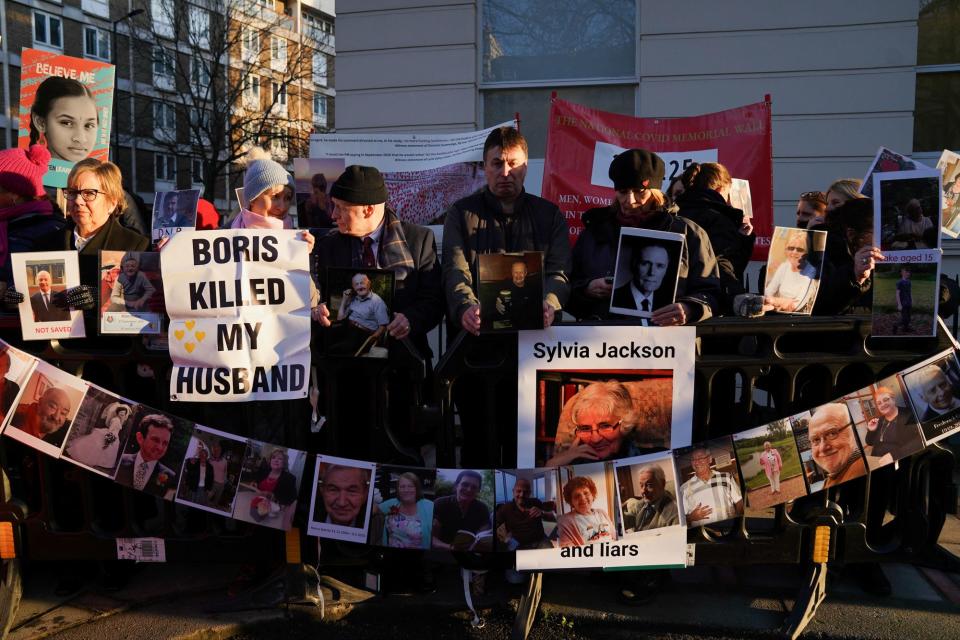 Protesters outside the inquiry held pictures of relatives who died during the pandemic (REUTERS)