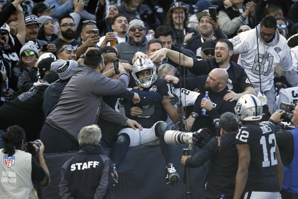 Oakland Raiders wide receiver Tyrell Williams is mobbed by fans after scoring a touchdown during the first half of an NFL football game against the Jacksonville Jaguars in Oakland, Calif., Sunday, Dec. 15, 2019. (AP Photo/Ben Margot)