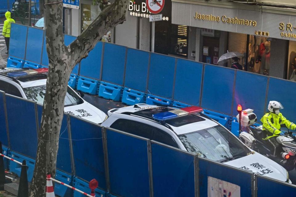 Police vehicles are seen next to Wulumuqi road, named for Urumqi in Mandarin, in Shanghai on November 29, 2022, two days after rare protests against China's zero-Covid policy following a deadly fire in Urumqi, the capital of the Xinjiang region. (Photo by HECTOR RETAMAL / AFP) (Photo by HECTOR RETAMAL/AFP via Getty Images) (AFP via Getty Images)