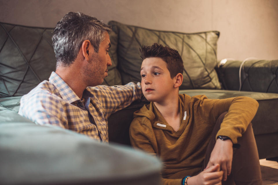 Dad talks with his son near a couch