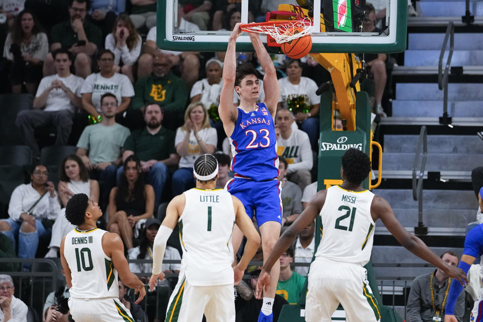 Kansas's Parker Braun (23) scores a basket in front of Baylor's RayJ Dennis (10), Miro Little (1) and Yves Missi (21) during the first half of an NCAA college basketball game, Saturday, March 2, 2024, in Waco, Texas. (AP Photo/Julio Cortez)