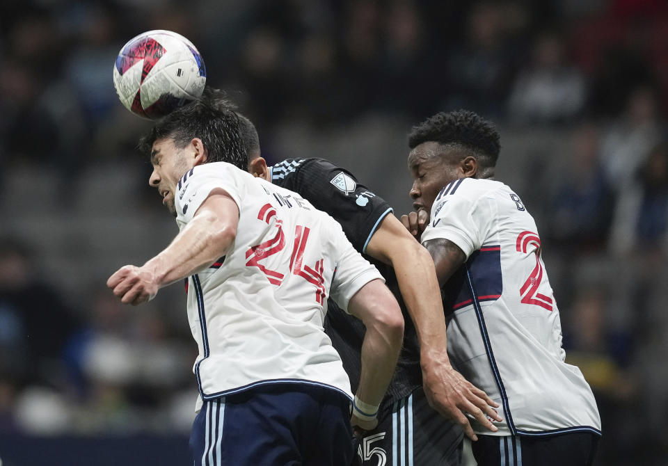 Vancouver Whitecaps' Brian White, left, and Javain Brown, right, vie for the ball against Minnesota United's Michael Boxall during the first half of an MLS soccer match in Vancouver, British Columbia., Saturday, May 6, 2023. (Darryl Dyck/The Canadian Press via AP)