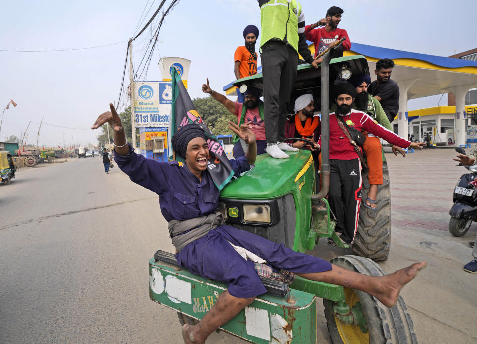 Farmers celebrate news of the repeal of farm laws they were protesting against, in Singhu, on the outskirts of New Delhi, India, Friday, Nov. 19, 2021. In a surprise announcement, India's Prime Minister Narendra Modi said Friday his government will withdraw the controversial agriculture laws that prompted yearlong protests from tens of thousands of farmers and posed a significant political challenge to his administration. (AP Photo/Manish Swarup)