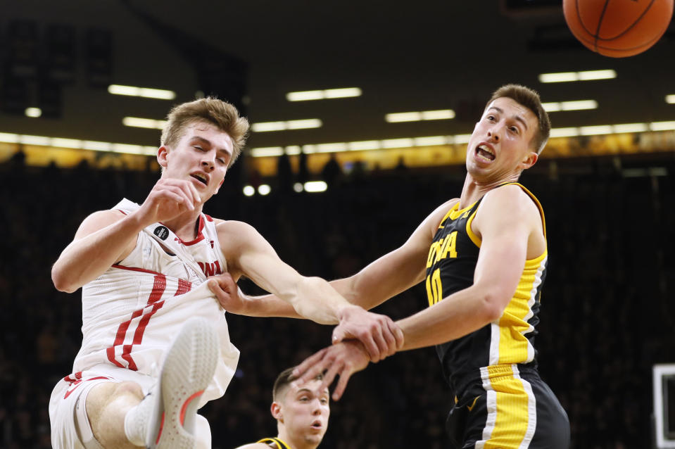 Wisconsin forward Tyler Wahl, left, fights for a rebound with Iowa guard Joe Wieskamp during the first half of an NCAA college basketball game, Monday, Jan. 27, 2020, in Iowa City, Iowa. (AP Photo/Charlie Neibergall)