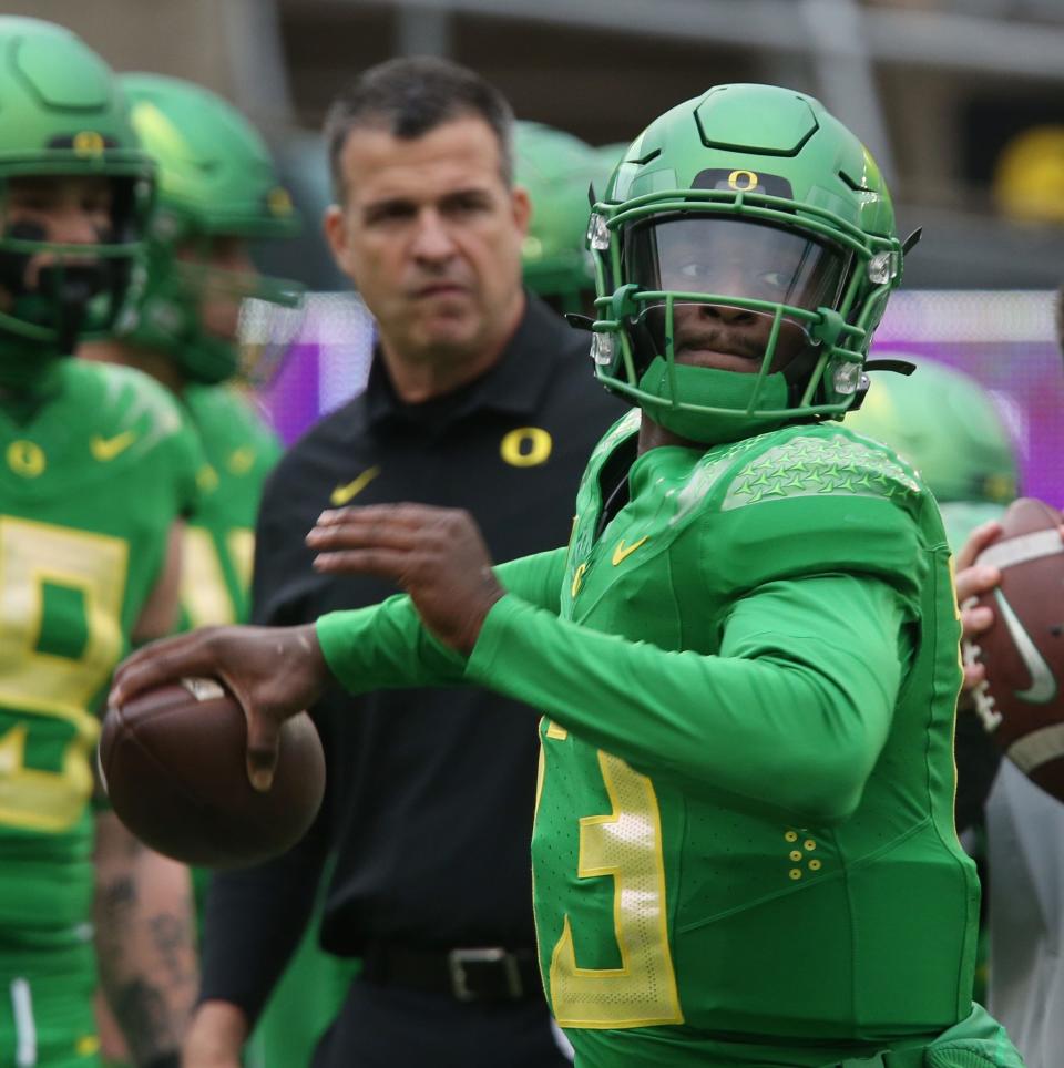 Oregon's Anthony Brown warms up under the watchful eye of coach Mario Cristobal before the Oregon State game at Autzen Stadium on Saturday.