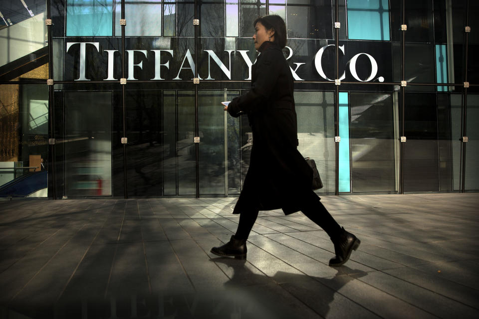 In this Thursday, Nov. 29, 2018, photo, a woman walks past a Tiffany & Co. store at a shopping mall in Beijing. The designer boutiques of Manhattan and Paris are feeling the chill of a Chinese economic slowdown that has hammered automakers and other industries. That is jolting brands such as Louis Vuitton and Burberry that increasingly rely on Chinese customers who spend $90 billion a year on jewelry, clothes and other high-end goods. The industry already is facing pressure to keep up as China’s big spenders shift to buying more at the spreading networks of luxury outlets in their own country. (AP Photo/Mark Schiefelbein)