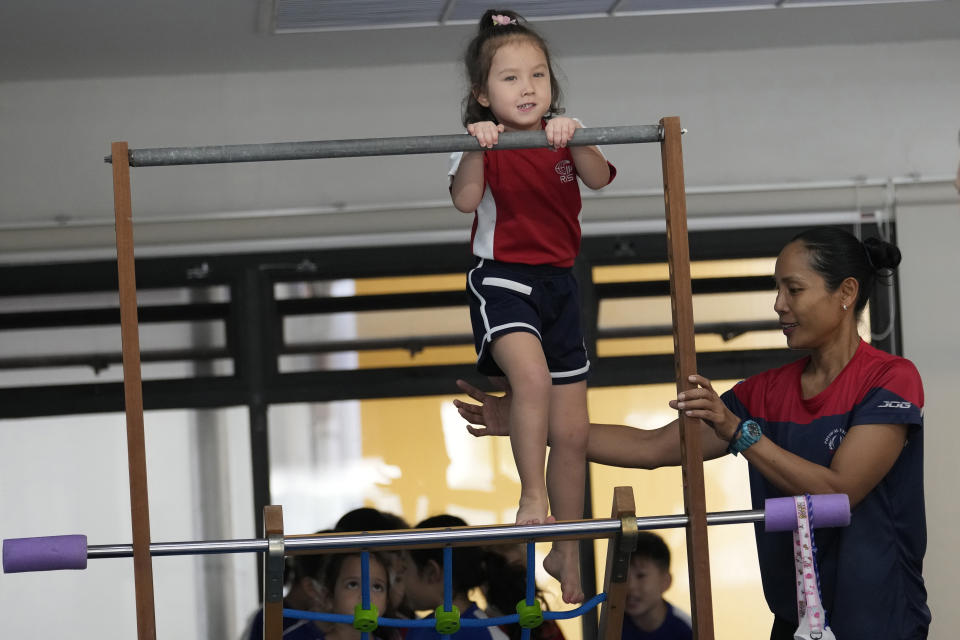 Rylae-Ann Poulin attends physical education class at Ruamrudee International School in Bangkok, Thailand, Friday, Jan. 13, 2023. The extremely rare AADC deficiency disorder afflicts about 135 children worldwide, many in Taiwan. Judy Wei, who was born in Taiwan, and her husband Richard Poulin III, sought out a doctor there who correctly diagnosed Rylae-Ann. They learned she could qualify for a gene therapy clinical trial in Taiwan. (AP Photo/Sakchai Lalit)