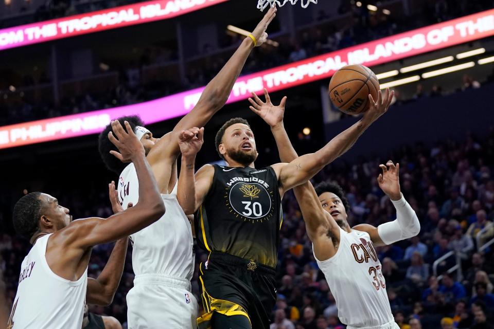 Golden State Warriors guard Stephen Curry shoots against Cleveland Cavaliers forward Evan Mobley, left, center Jarrett Allen and forward Isaac Okoro (35) during the second half in San Francisco, Friday, Nov. 11, 2022.