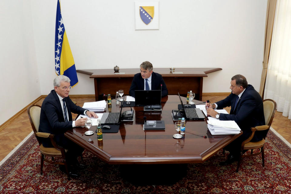 Members of Bosnia's tripartite presidency, Muslim member Sefik Dzaferovic, left, Croat member Zeljko Komsic and Bosnian Serb member Milorad Dodik, right, speak during a meeting in Sarajevo, Bosnia, Tuesday, Aug. 20, 2019. A meeting Tuesday between Bosnia's Muslim, Serb and Croat leaders ended without an agreement on forming the new cabinet because the Bosnian Serb member of the presidency, Milorad Dodik, was against a package that would also include adopting an action plan that would move Bosnia closer to NATO membership. (Harun Muminovic/FENA via AP)