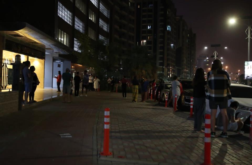 People gather in front of their residential building in the Gulf emirate of Dubai, United Arab Emirates, in the early hours of 2 July 2022. A recorded earthquake of magnitude 6.3 has hit southern Iran with tremors felt in Dubai (EPA)