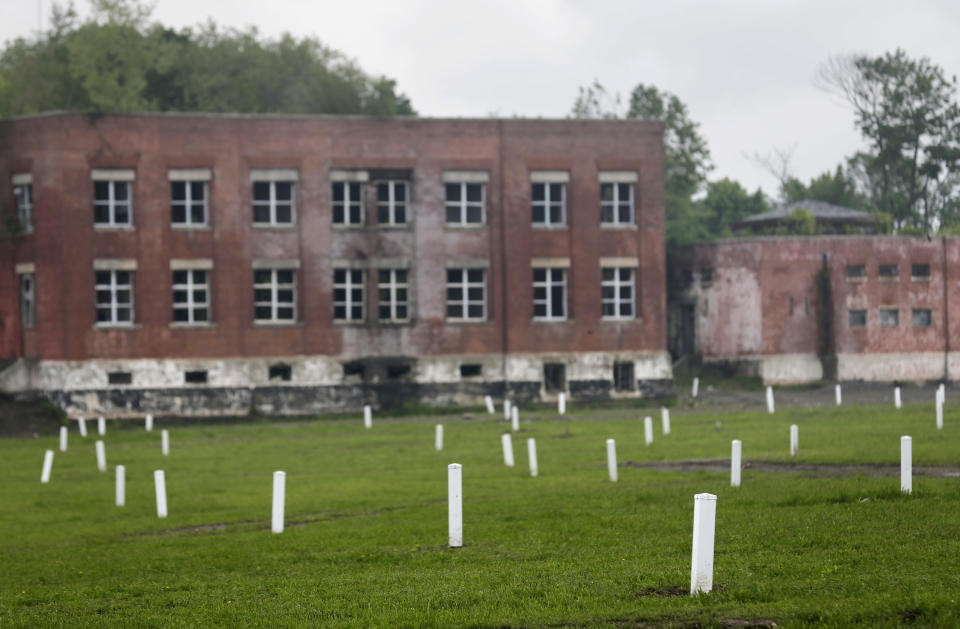 FILE - This May 23, 2018, file photo, shows graves marked by white markers on Hart Island in New York. On Monday, April 6, 2020, New York City Mayor Bill de Blasio said that officials are exploring the possibility of temporarily burying coronavirus victims on Hart Island, a one-mile, limited access strip off the Bronx borough of New York that has long served as the city's potter's field. (AP Photo/Seth Wenig, File)